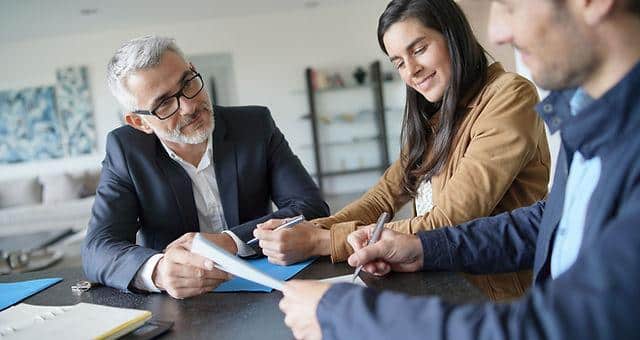 Home buyers signing closing documents during a real estate closing in Texarkana